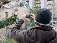 Una persona fotografa la casa devastata di via Baiamonti (Foto Massimo Silvano)