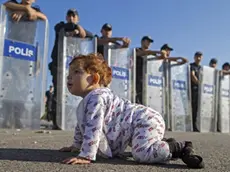 Una bimba profuga davanti alla polizia schierata