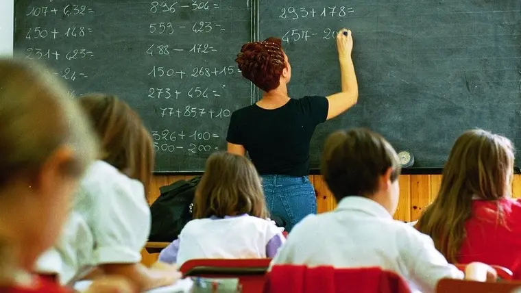 Un'insegnante alla lavagna durante una lezione di matematica