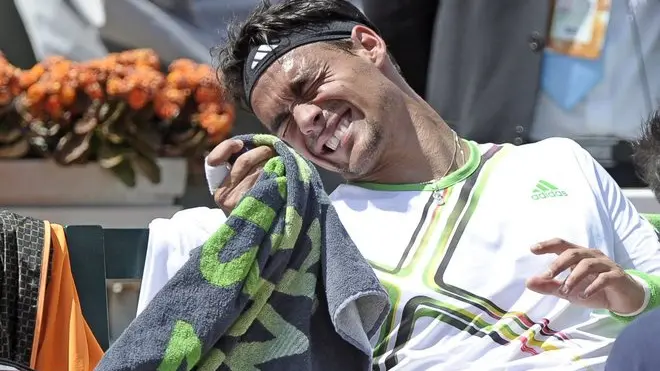 epa02757639 Fabio Fognini of Italy receives treatment as he plays Albert Montanes of Spain in their fourth round match for the French Open tennis tournament at Roland Garros in Paris, France, 29 May 2011. EPA/CHRISTOPHE KARABA