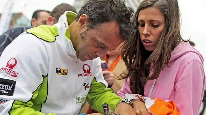 epa02989329 Italian MotoGP rider Loris Capirossi, 38, signs autographs to his followers during a farewell ceremony in his honour held in Valencia, eastern Spain on 02 November 2011. After 22 seasons in the sport, the Pramac Racing rider will retire of competing this weekend. Capirossi has won three world titles, one in 250cc and two in 125cc, 29 races and stepped onto the podium 99 times. EPA/MANUEL BRUQUE
