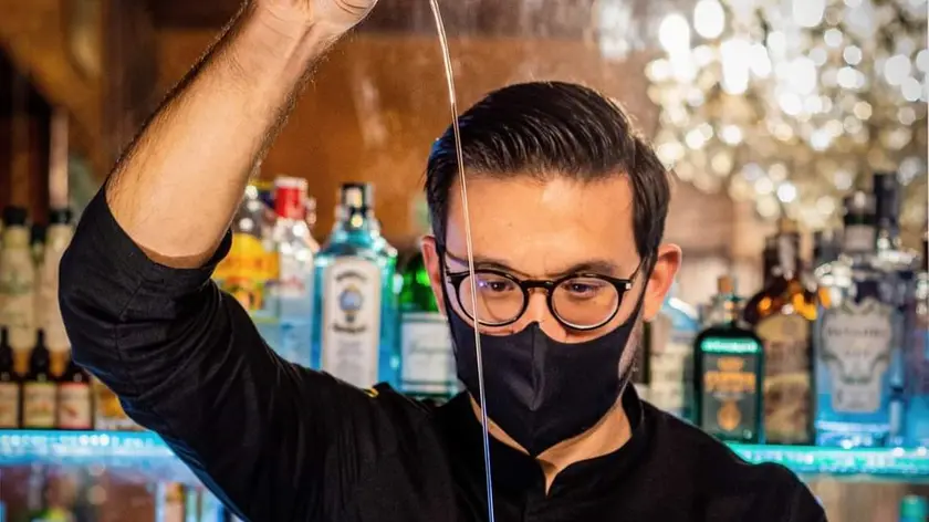 Pizzolini impegnato nella preparazione di un cocktail dietro il bancone dell’Antico Caffè Torinese