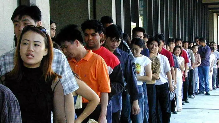 20020910 - PRATO- CRO : IMMIGRAZIONE: FILE PER SANATORIA. Le lunghe code di immigrati cinesi che si sono verificate davanti alle sedi delle Poste di Prato per ritirare e consegnare i moduli della sanatoria. MARCO BUCCO / ANSA / PAL