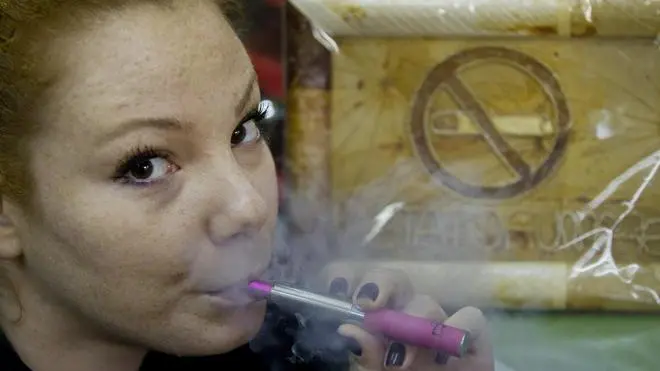 Una ragazza fuma una sigaretta elettronica in un locale pubblico a Roma. 27 dicembre 2012. ANSA/CLAUDIO PERI