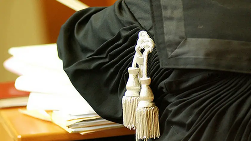 Un avvocato indossa la toga durante un’udienza in tribunale