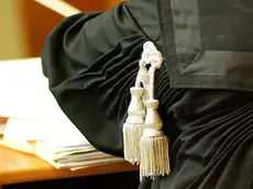 Un avvocato indossa la toga durante un’udienza in tribunale