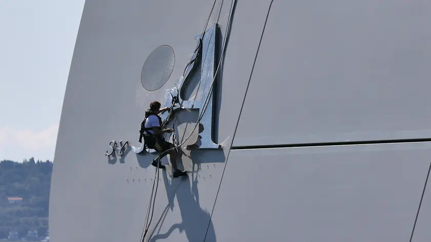 Un addetto pulisce la lettera “A” sullo yacht (Lasorte)