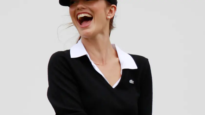 American actress Minka Kelly laughs after missing to hit the ball to tee off during the pro-am games at the World Celebrity Pro-Am golf tournament in Haikou, in southern China's island province Hainan on Friday, Oct. 19, 2012. (AP Photo/Eugene Hoshiko)