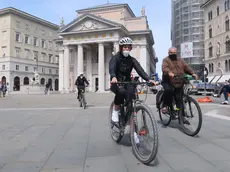 Due ciclisti con mascherina in piazza della Borsa (Lasorte)