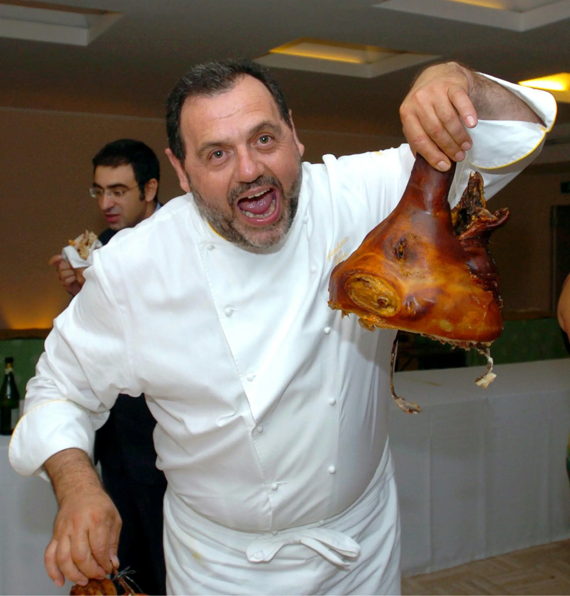 GIANFRANCO VISSANI- Lo chef Gianfranco Vissani scherza con la testa di una porchetta che ha appena terminato di servire durante una serata a Roma il 23 giugno 2005. DE RENZIS/ANSA