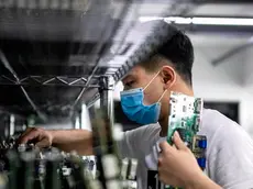 epa08296711 A man works in the VDWALL factory in Shenzhen, Guangdong province, China, 13 March 2020 (issued 16 March 2020). China's value-added industrial output, an important economic indicator, fell 13.5 percent year-on-year in the first two months of 2020 as the coronavirus outbreak hurt activities, according to a report issued by the National Bureau of Statistics on 16 March 2020. VDWALL is a high-tech enterprise specializing in developing and manufacturing video processing equipment for LED displays. EPA/ALEX PLAVEVSKI