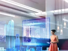 Caucasian businesswoman using hologram computer screen --- Image by © Colin Anderson/Blend Images/Corbis