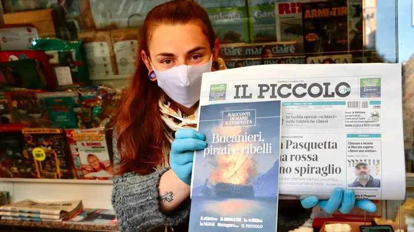 Un'edicolante mostra il libro in omaggio oggi, domenica 4 aprile. Foto Silvano
