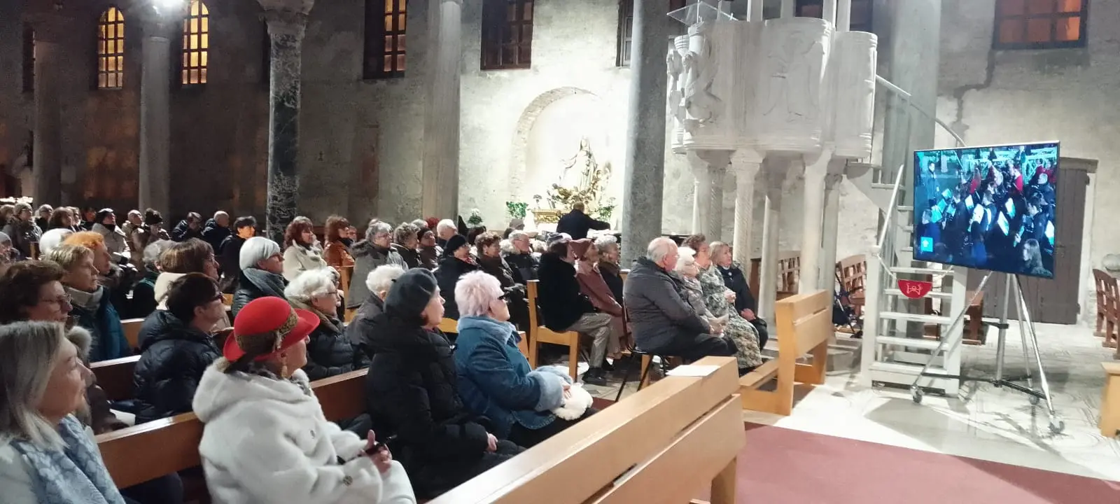 I fedeli nella basilica di Grado mentre seguono la cerimonia