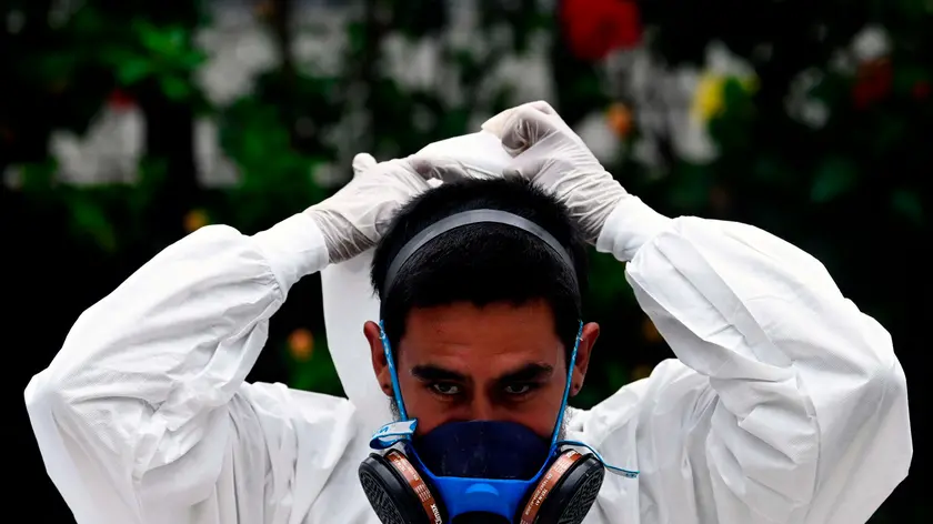 A worker at the Municipal Pantheon poses for a picture before the burial of an alleged COVID-19 coronavirus victim, in the municipality of Antiguo Cuscatlan, El Salvador, on June 22, 2020. (Photo by MARVIN RECINOS / AFP)