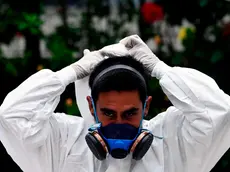 A worker at the Municipal Pantheon poses for a picture before the burial of an alleged COVID-19 coronavirus victim, in the municipality of Antiguo Cuscatlan, El Salvador, on June 22, 2020. (Photo by MARVIN RECINOS / AFP)