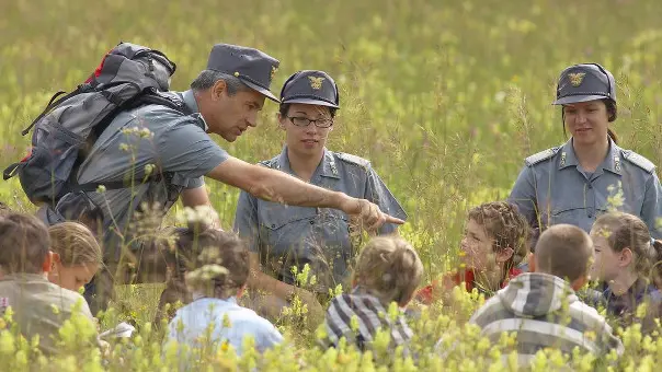 Guardie forestali impegnate in una lezione all'aperto con piccoli allievi