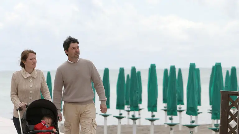 Turisti a passeggio nella spiaggia deserta
