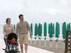 Turisti a passeggio nella spiaggia deserta