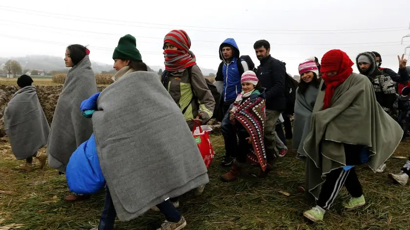 Refugees walk from Croatia to Slovenia through a green field near Rigonce village at the Slovenian border, 25 October 2015. .ANSA/ANTONIO BAT