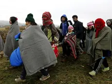 Refugees walk from Croatia to Slovenia through a green field near Rigonce village at the Slovenian border, 25 October 2015. .ANSA/ANTONIO BAT