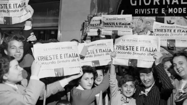 10 Oct 1954, Trieste, Italy --- Displaying special editions, these residents of Trieste hold aloft for all to see the news that final agreement has been reached between Italy and Yugoslavia over the much disputed Trieste free territory. Under the terms of the agreement, which was signed in London, Italy takes control of the Port of Trieste and Zone A while Yugoslavia retains control of Zone B. --- Image by © Bettmann/CORBIS