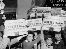 10 Oct 1954, Trieste, Italy --- Displaying special editions, these residents of Trieste hold aloft for all to see the news that final agreement has been reached between Italy and Yugoslavia over the much disputed Trieste free territory. Under the terms of the agreement, which was signed in London, Italy takes control of the Port of Trieste and Zone A while Yugoslavia retains control of Zone B. --- Image by © Bettmann/CORBIS