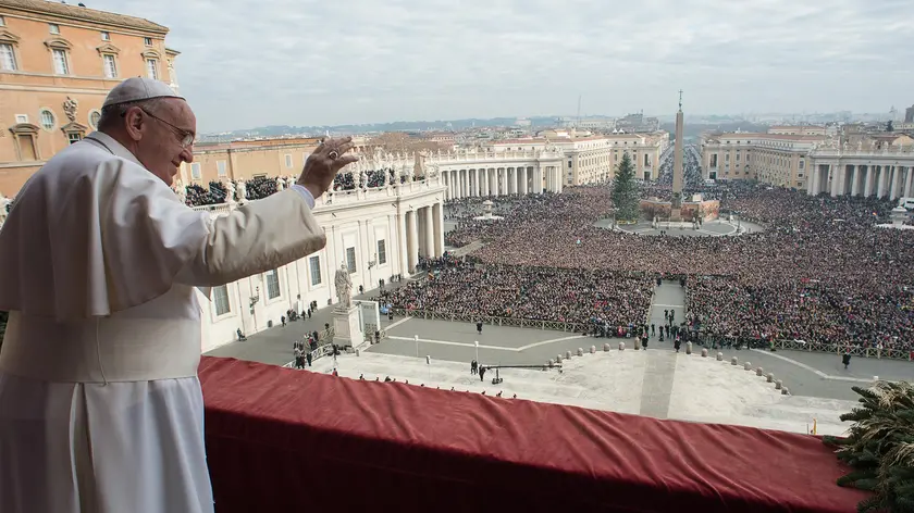 The picture released by the Vatican press office shows Pope Francis giving his traditional Christmas "Urbi et Orbi" blessing from the balcony of Saint Peter's Basilica at the Vatican City, 25 December 2014. ANSA/OSSERVATORE ROMANO