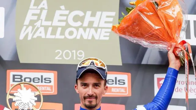 epa07525318 French rider Julian Alaphilippe of the Deceuninck-Quick Step team celebrates on the podium after winning the Fleche Wallonne one day cycling race over 195km from Ans to Huy, Belgium, 24 April 2019. EPA/JULIEN WARNAND