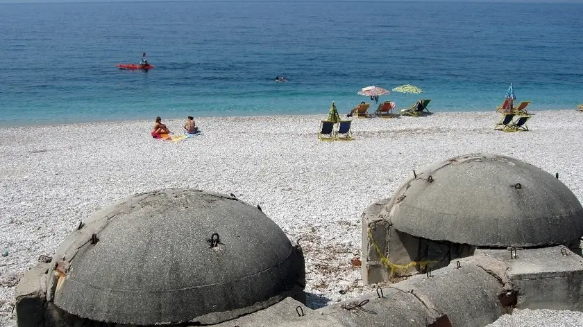 Due Albanie in una foto: quella di ieri con i bunker di Hoxha e quella di oggi coi bagnanti sulla spiaggia (Rtvslo.si)