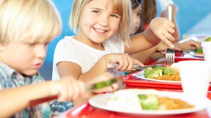 Elementary Pupils Enjoying Healthy Lunch In Cafeteria