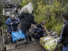 Civili mentre attraversano il ponte distrutto di Stanytsia Luhanska