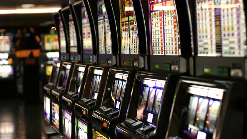 Una fila di slot machine in una sala giochi