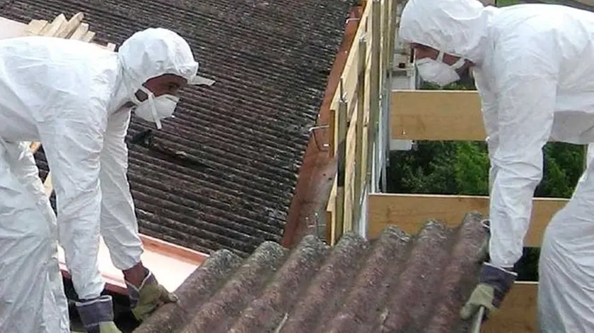 Operazioni di bonifica dall'amianto su una tettoia