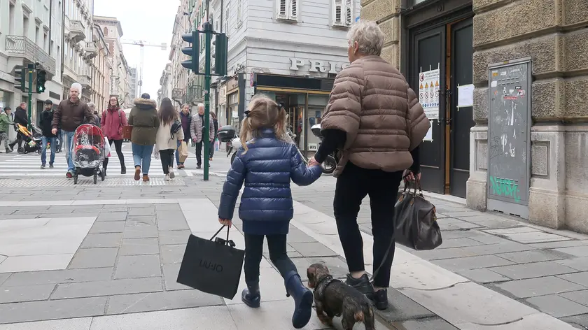 Una bimba a spasso con la nonna in zona pedonale a Trieste. Foto Andrea Lasorte