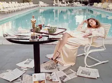 American actress Faye Dunaway takes breakfast by the pool with the day's newspapers at the Beverley Hills Hotel, 29th March 1977. She seems less than elated with her success at the previous night's Academy Awards ceremony, where she won the 1976 Oscar for Best Actress in a Leading Role for 'Network'.