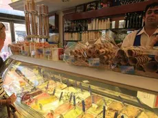 Alcuni turisti comprano un gelato artigianale in una gelateria di piazza fontana di Trevi a Roma, in una foto d'archivio. Rallenta l'emorragia di negozi e piccole botteghe al dettaglio che tra maggio e giugno tornano, per la prima volta dal 2012, a registrare un saldo positivo tra chiusure e aperture (+1.422), grazie soprattutto alla vitalità del Nord Italia. Sono i dati dell'Osservatorio Confesercenti che nel terzo bimestre 2013 rileva un 'piccolo boom' di aperture: 7.546 nuove imprese, +88% rispetto a marzo-aprile (4.014). Da inizio 2013 hanno però chiuso senza essere sostituite 11.328 imprese..ANSA/LUCIANO DEL CASTILLO