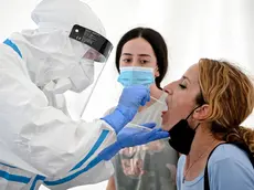 epa08592314 A traveler gets her swab sample collected in a Covid-19 walk-in test center at the Cologne Bonn Airport in Cologne, Germany, 08 August 2020. Effective from 08 August 2020, it is mandatory for travelers arriving to Germany from a risk country, to undergo a coronavirus test. EPA/SASCHA STEINBACH