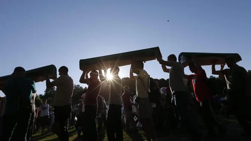 epa04841345 Bosnian muslim men carry coffins with remains of relatives at the Potocari Memorial Center in Srebrenica, Bosnia and Herzegovina, 10 July 2015. A total of 136 newly-identified Bosnian Muslims will be buried on 11 July 2015 as part of a memorial ceremony to mark the 18th anniversary of the Srebrenica massacre. July 2015 marks the 20-year anniversary of the Srebrenica Massacre that saw more than 8,000 Bosnians men and boys killed by Bosnian Serb forces during the Bosnian war. On 08 July Russia vetoed a United Nations Security Council resolution that would have labeled as genocide the 1995 massacre of Muslims in Srebrenica by ethnic Serbs. EPA/VALDRIN XHEMAJ