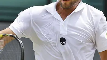 Simone Bolelli of Italy leaps in the air as he plays a return to Philipp Kohlschreiber of Germany during their match at the All England Lawn Tennis Championships in Wimbledon, London, Thursday, June 26, 2014. (AP Photo/Alastair Grant)