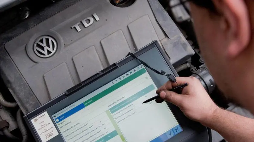 (FILE) A file picture dated 08 October 2015 shows an automobile service technician with a diagnostic device in front of a 2.0l TDI type EA189 diesel engine in a VW Touran in an auto repair shop in Hanover, Germany. An emissions-cheating scandal affecting 11 million Volkswagen cars worldwide widened on 22 October 2015 as Europe's biggest carmaker said it is investigating whether a second type of engine had cheating software installed. So far, the crisis has revolved around EA 189 diesel engines in Volkswagen, Audi, Seat and Skoda cars and vans. The company is now looking at the earliest versions of the EA 288 engine introduced in 2012 as a successor to the EA 189, a spokesman said. ANSA/JULIAN??STRATENSCHULTE