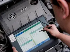 (FILE) A file picture dated 08 October 2015 shows an automobile service technician with a diagnostic device in front of a 2.0l TDI type EA189 diesel engine in a VW Touran in an auto repair shop in Hanover, Germany. An emissions-cheating scandal affecting 11 million Volkswagen cars worldwide widened on 22 October 2015 as Europe's biggest carmaker said it is investigating whether a second type of engine had cheating software installed. So far, the crisis has revolved around EA 189 diesel engines in Volkswagen, Audi, Seat and Skoda cars and vans. The company is now looking at the earliest versions of the EA 288 engine introduced in 2012 as a successor to the EA 189, a spokesman said. ANSA/JULIAN??STRATENSCHULTE