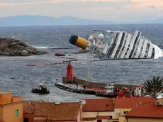 Costa Concordia all'isola del Giglio adagiata sul fianco davanti all'entrata del porto il 1 febbraio 2012. ANSA/LUCA ZENNARO