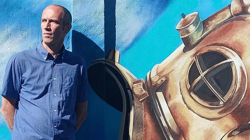 Lo street artist Federico Duse, accanto a una sua opera