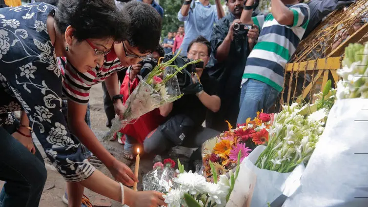 Members of an Indian family offer flowers and light candles as they pay tribute to those killed outside the Holey Artisan Bakery in Dhaka, Bangladesh, Sunday, July 3, 2016. The assault on the restaurant in Dhaka's diplomatic zone by militants who took dozens of people hostage marks an escalation in militant violence in the Muslim-majority nation. (AP Photo)