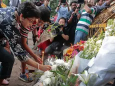 Members of an Indian family offer flowers and light candles as they pay tribute to those killed outside the Holey Artisan Bakery in Dhaka, Bangladesh, Sunday, July 3, 2016. The assault on the restaurant in Dhaka's diplomatic zone by militants who took dozens of people hostage marks an escalation in militant violence in the Muslim-majority nation. (AP Photo)