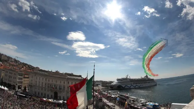 Un'immagine del Giro a Trieste con le Frecce Tricolori sullo sfondo