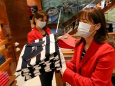 Women with protective masks are preparing to open a store in Vienna, Austria, Tuesday, April 14, 2020. Smaller Austrian shops may reopen with special protective measures from Tuesday on. The Austrian government has moved to restrict freedom of movement for people, in an effort to slow the onset of the COVID-19 coronavirus. The new coronavirus causes mild or moderate symptoms for most people, but for some, especially older adults and people with existing health problems, it can cause more severe illness or death. (AP Photo/Ronald Zak)