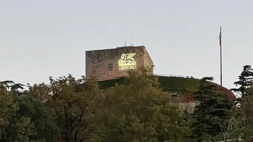 Il logo delle Generali proiettato sul Castello di San Giusto