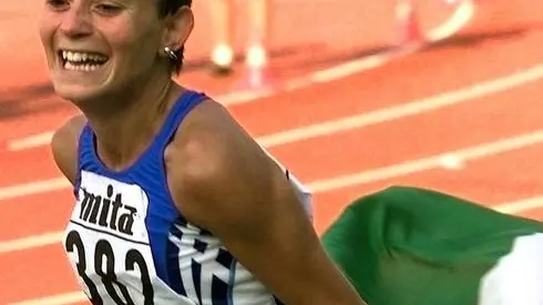 L'italiana Annarita Sidoti esultante compie il giro dello stadio con la bandiera italiana dopo aver vinto la medaglia d'oro nei dieci km di marcia dei mondiali di atletica leggera ad Atene, il 7 agosto 1997. ANJA NIEDRINGHAUS/ANSA/TO